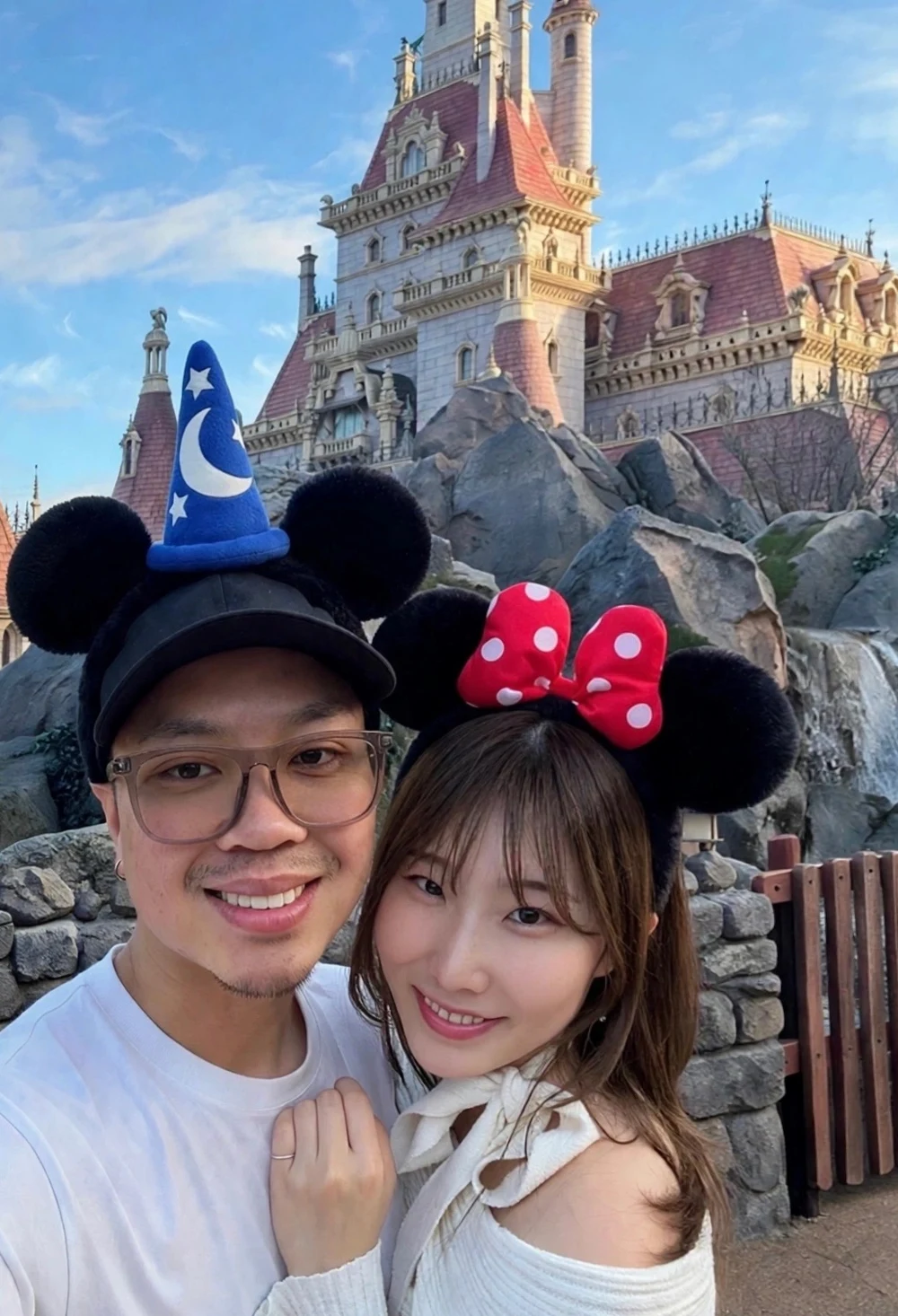 Aaron and Maya in front of the Beauty and the Beast castle at Tokyo Disneyland